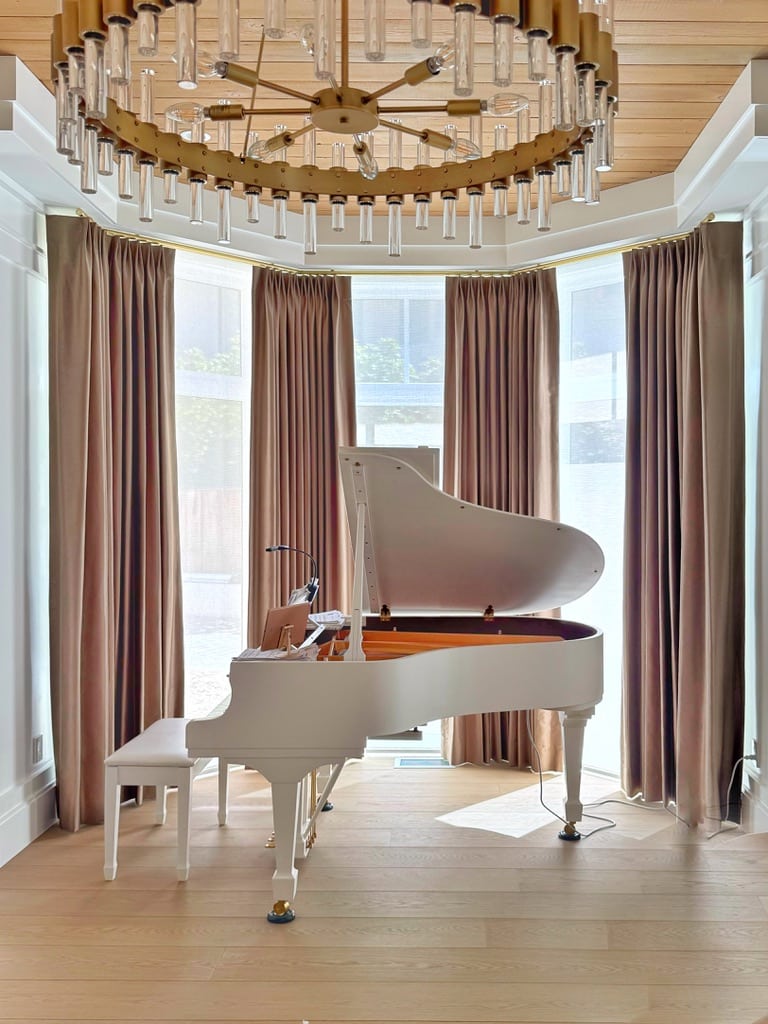 These elegant drapery panels add drama to the piano area. Concealed screen shades lower automatically when protection from the sun is needed.