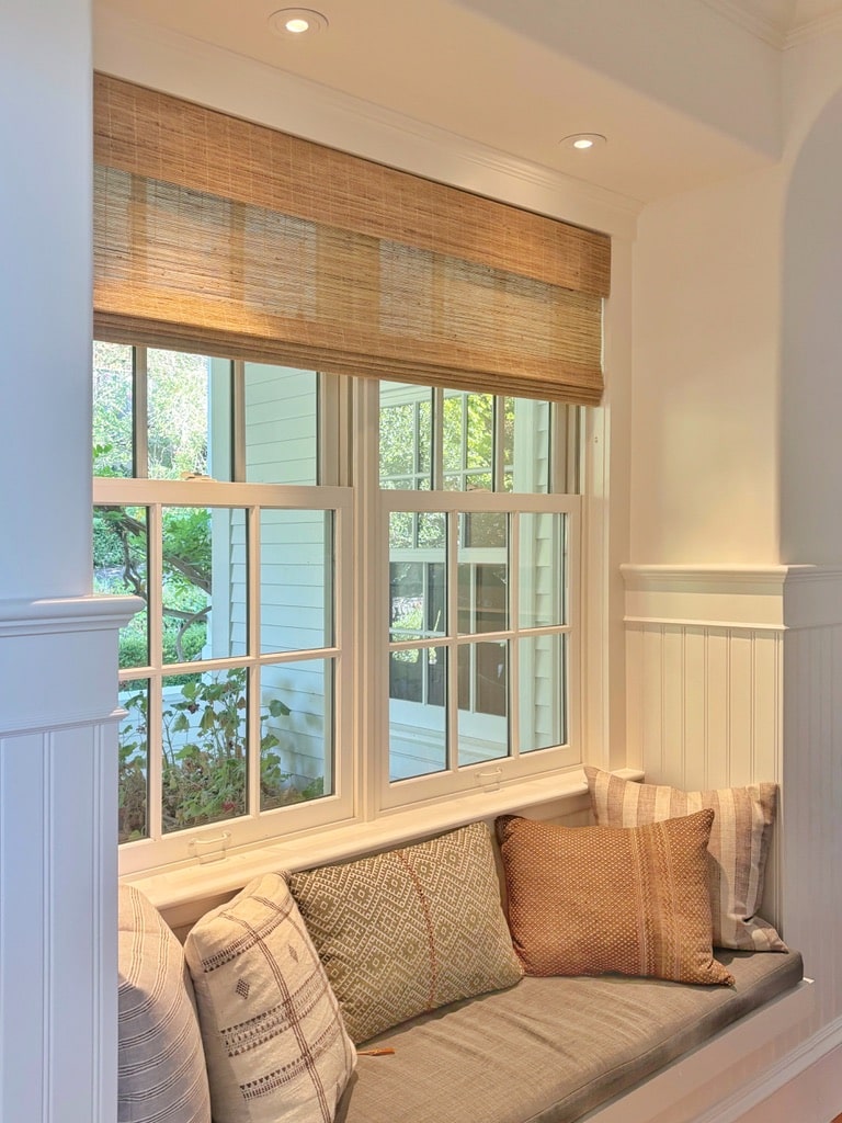 Unlined Hunter Douglas Provenance shades are used in a stationary manner to elevate this entry bench area.