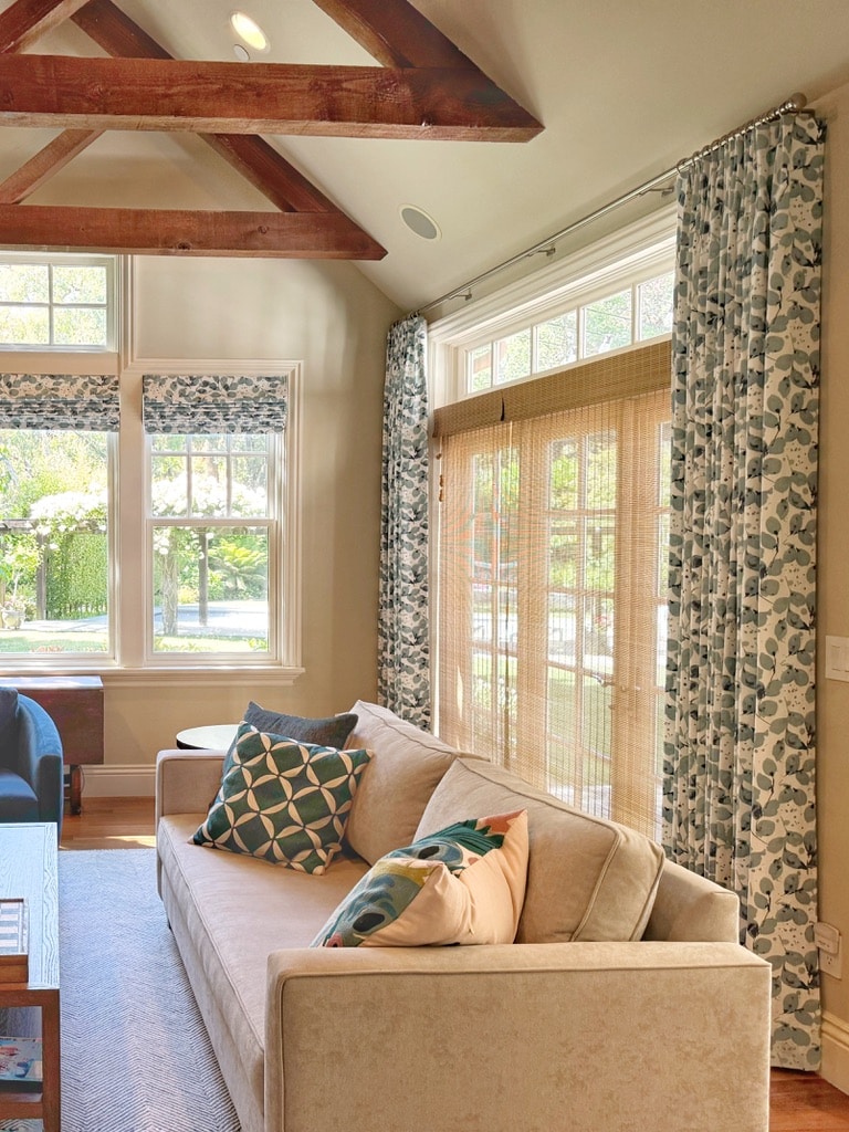 Custom drapes match the custom roman shades, and the layer of unlined woven woods filter enough sunlight without closing the room to the outdoors.